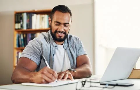 Man, writing and notebook for remote work from home office with laptop, smi.. Stock Photos