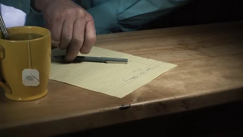 Man Writing and Stirring Tea Cup Slider Stock Footage 70173320