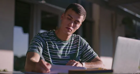 Man, writing and university student with laptop outdoor for learning, music and Video stock 307748588