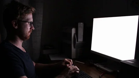 Man writing behind glowing computer monitor Stock Footage 97736277