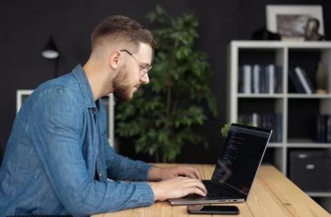 Man writing code on laptop Stock-Fotos