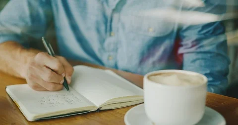 Man Writing in Coffee Shop Stock Footage 86781575