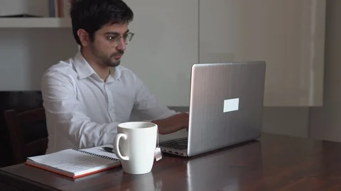 Man writing on the computer and taking notes with pen on the desk Stock Footage 129442889