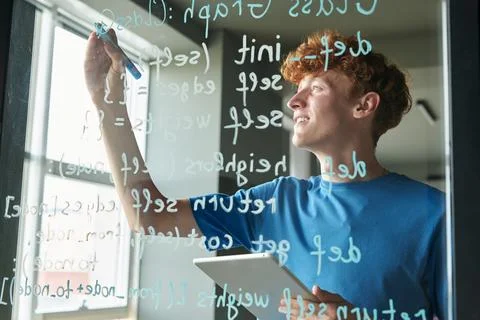 Man writing Computer Code on Glass Wall Stock-Fotos
