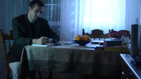 Man writing in dining room Stock Footage 34293939