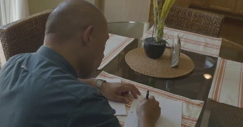 Man writing down a list on the paper at table Stock Footage 83187101