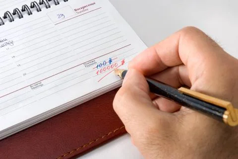 	The man writing down in weekly. Stock Photos