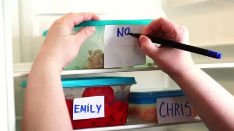 Man writing dramatic and angry note on meal container in work fridge. Office Stock Footage 314597448