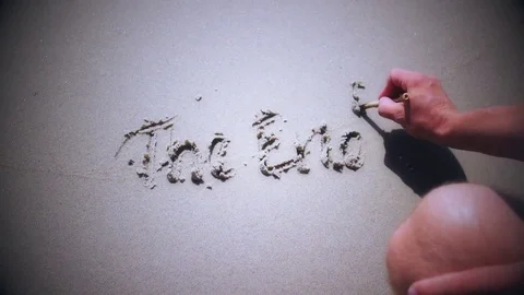 Man writing THE END on sand of beach with a wave Stock Footage 71141305