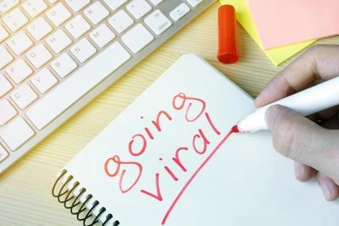 Man writing going viral in a note pad. Stock Photos