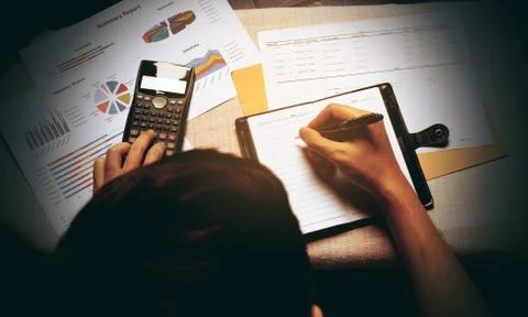 Man writing make note and doing calculate finance at home office. Stock Photos
