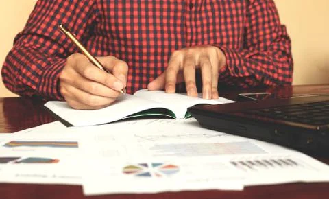 Man writing make notes with calculate about cost at home office. Stock Photos