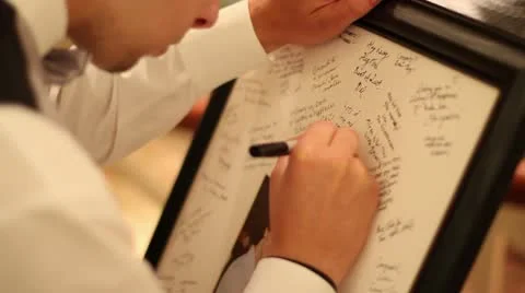 Man Writing Note on Picture at Wedding Video stock 11884411