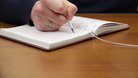 A man is writing in a notebook Stock Footage 99864821
