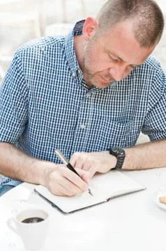 Man Writing in Notebook Stock Photos