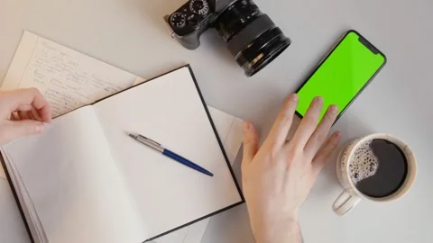 Man Writing in Notebook then Taps Green Screen Phone in Slowmotion 動画素材 176974524