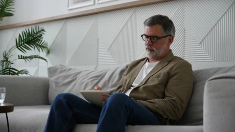 Man writing in notebook white sitting on sofa Stock Footage 278987175