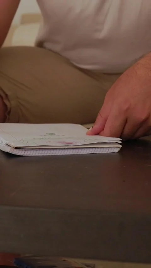 Man writing on notepad in living room Stock Footage 327862722