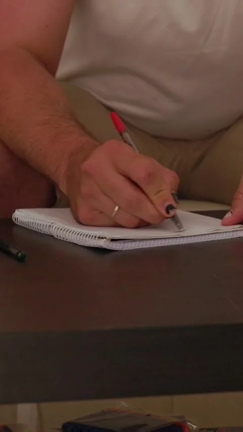 Man writing on notepad in living room Stock Footage 327862780