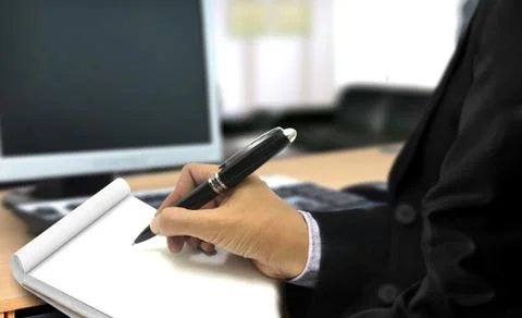 Man writing on notepad in the office Stock Photos