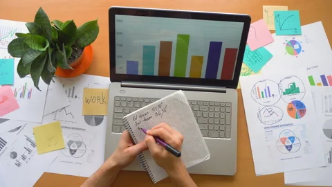 Man writing in notepad at office surrounded by a lot of paperwork, top view Stock Footage 87900035