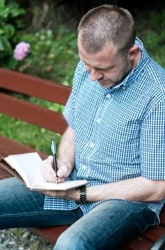Man writing in notepad Stock Photos