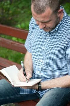 Man writing in notepad Stock Photos