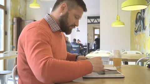 Man writing notes in calendar, profile shot, in cafe, indoor, steadicam Video stock 73266773