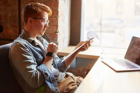Man writing in the notes he made earlier. Stock Photos