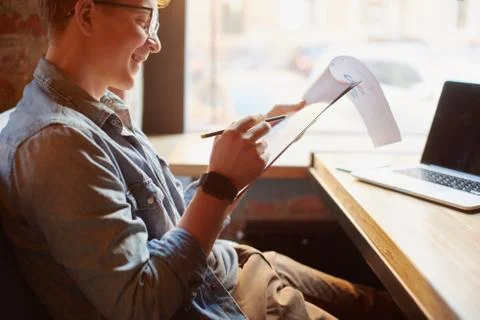 Man writing in the notes he made earlier. Stock Photos