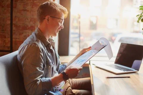 Man writing in the notes he made earlier. Stock Photos