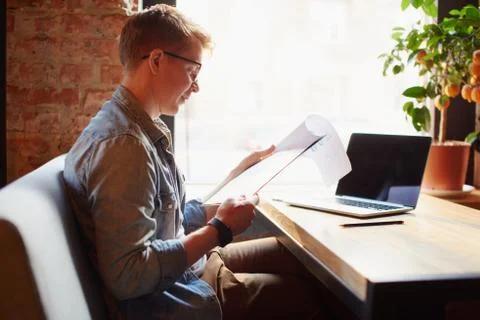 Man writing in the notes he made earlier. Stock Photos