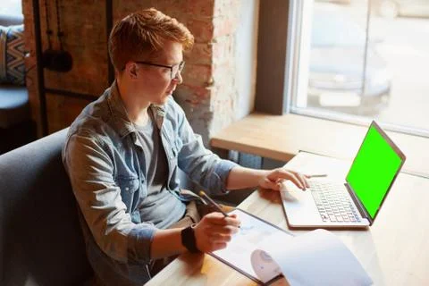 Man writing in the notes he made earlier. Stock Photos