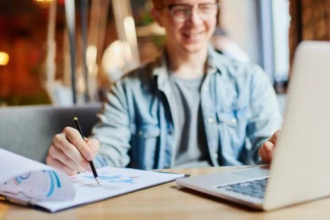 Man writing in the notes he made earlier. Stock Photos