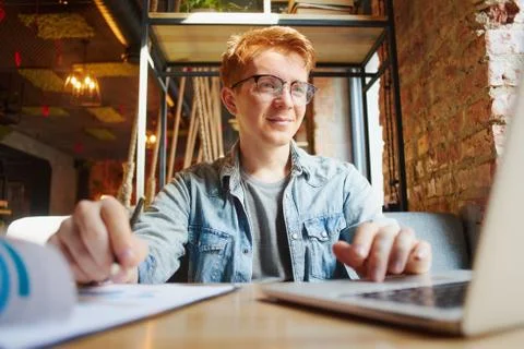 Man writing in the notes he made earlier. Stock Photos