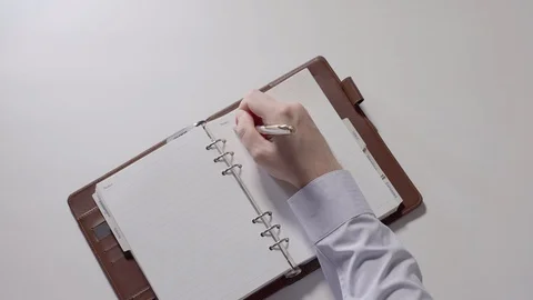 Man is writing notes in notebook. Part 06. Stock Footage 94184645