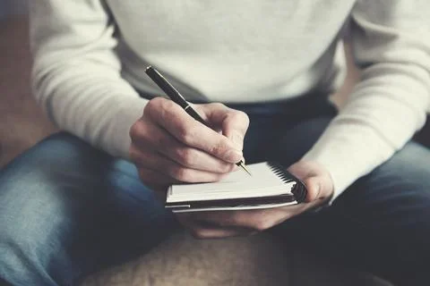 A man  writing notes in a notebook Stock Photos