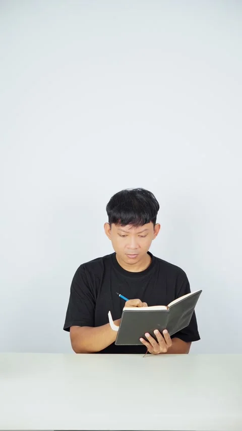 Man Writing Notes in Notebook on White Background 스톡 동영상 347105402