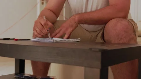 Man writing notes on notepad in split screen Stock Footage 316128186