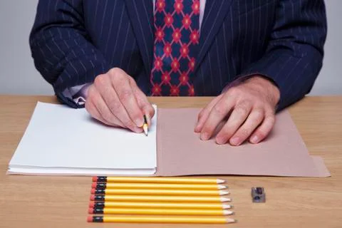 Man writing on paper with tiny pencil Stockfoto's