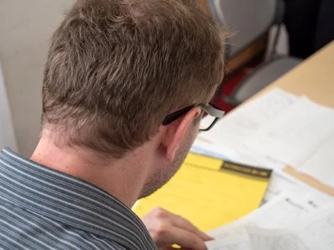 A man writing up paperwork at work. Foto stock