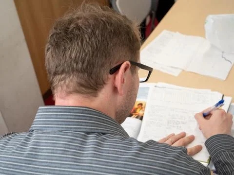 A man writing up paperwork at work. Stock Photos