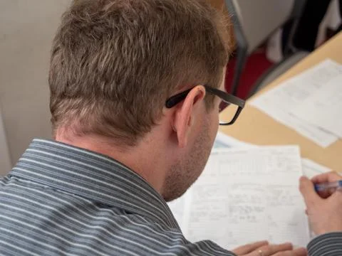 A man writing up paperwork at work. Stock Photos