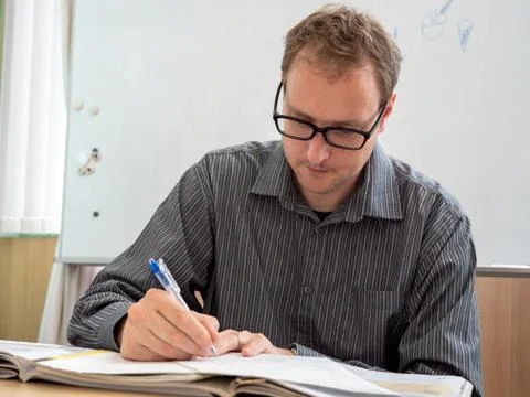 A man writing up paperwork at work. Stock Photos