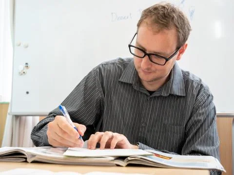 A man writing up paperwork at work. Stock Photos