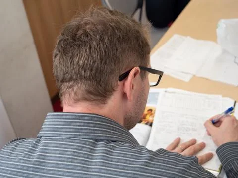 A man writing up paperwork at work. Foto stock