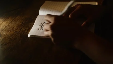 Man writing personal goals in notebook at night Video stock 327307381