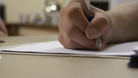 Man Writing On A Piece Of Paper Stock Footage 156765405