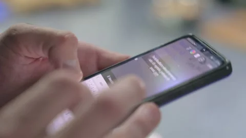 Man writing a post in his cellphone in the kitchen of a restaurant. Stock Footage 240782855