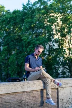 Man writing, sitting on the wall. Stock-Fotos